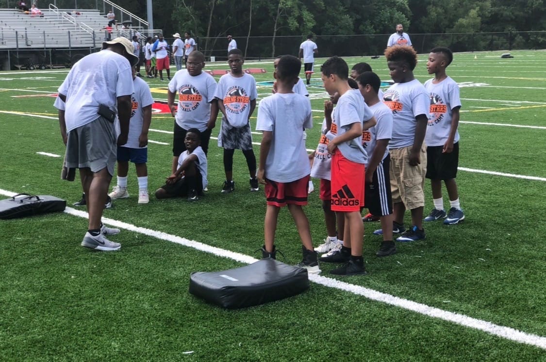 Young athletes working through drills at a Legacy Coaches Network football camp.